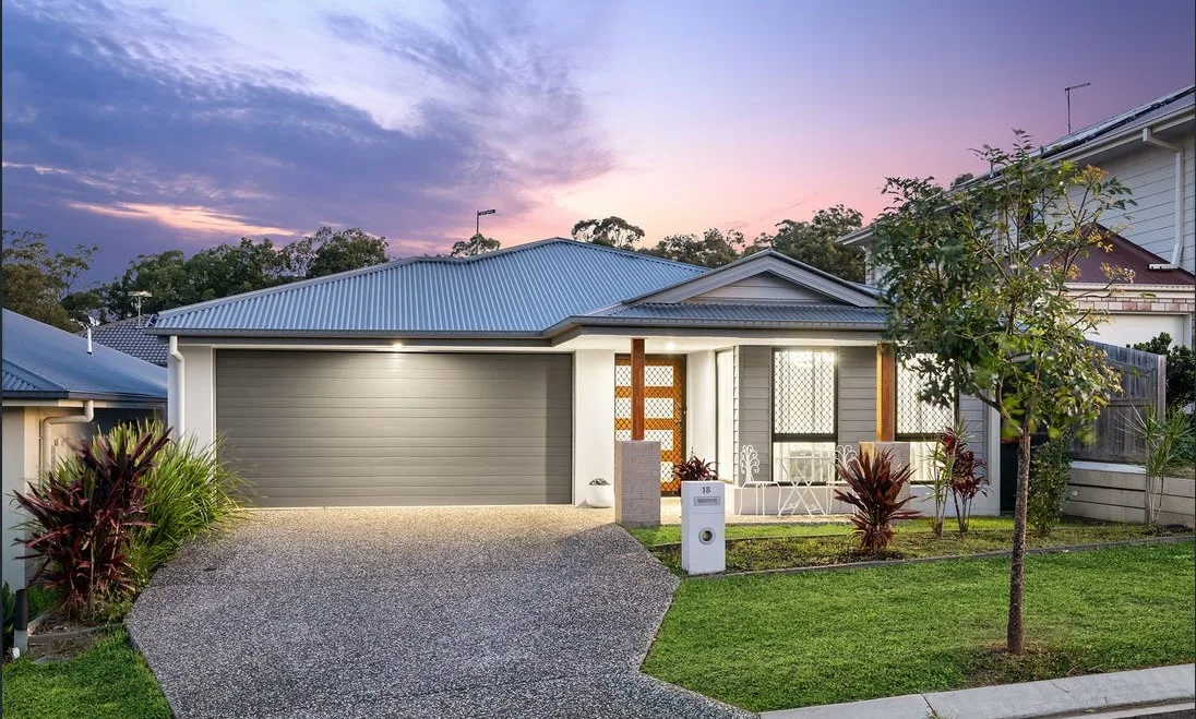 Exposed aggregate concrete driveway in front of a new home at sunset